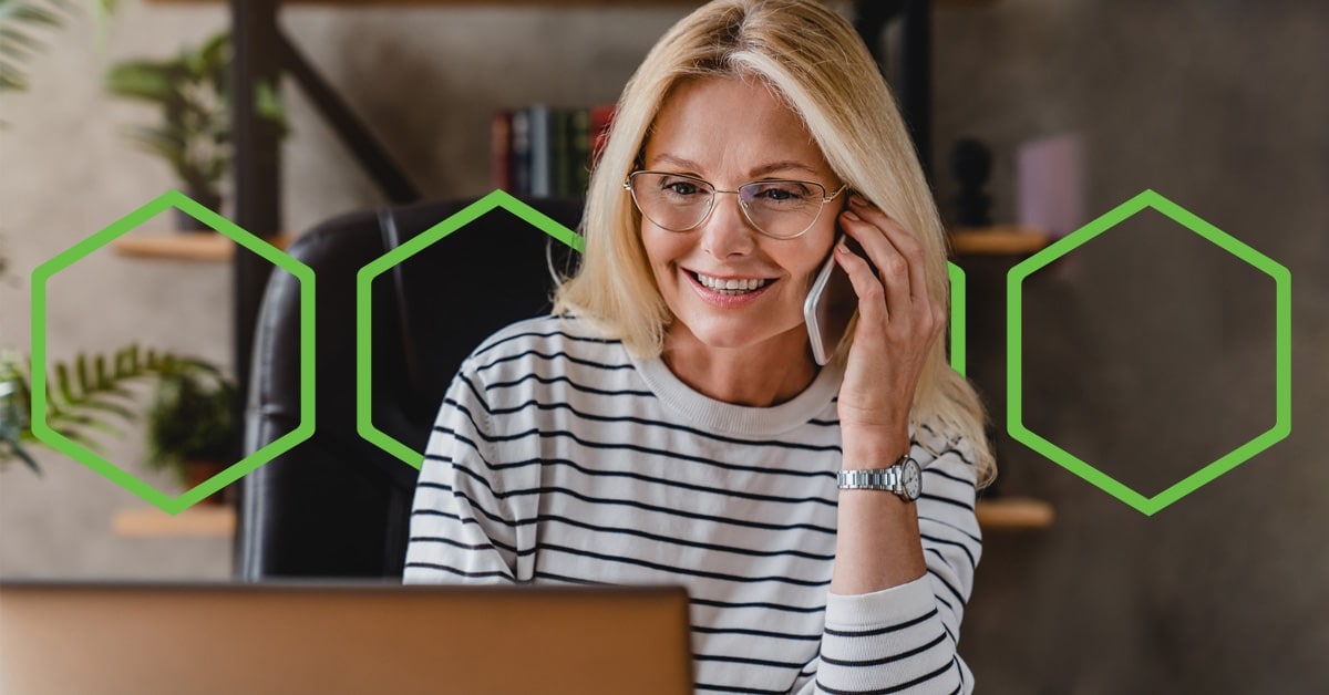 Woman talking on phone and looking at her computer