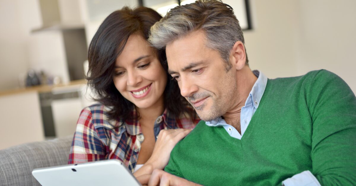 a couple looks at a tablet screen